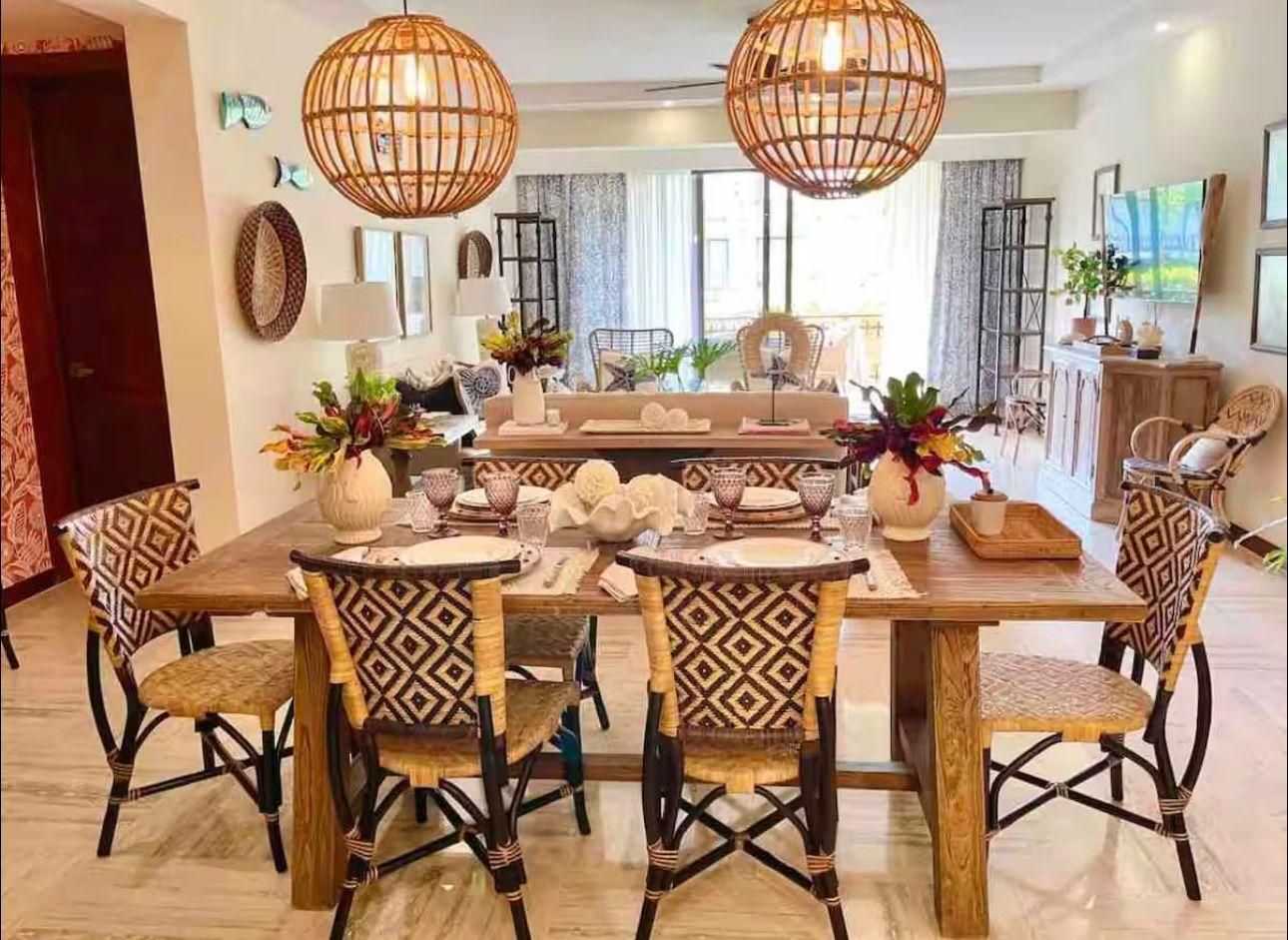 Comedor amueblado con lámparas de ratán y cocina equipada