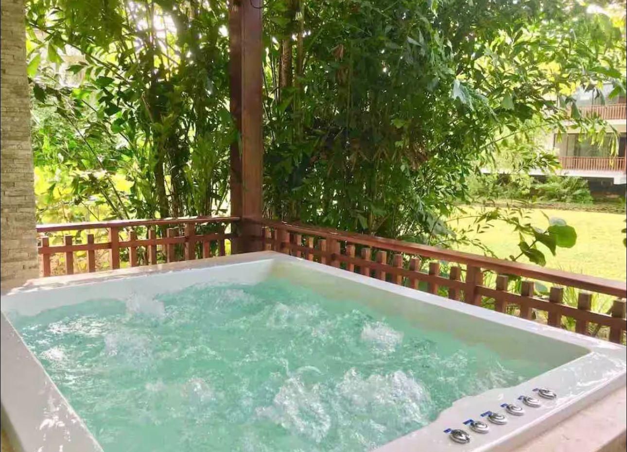 Jacuzzi privado en la terraza, rodeado de vegetación tropical