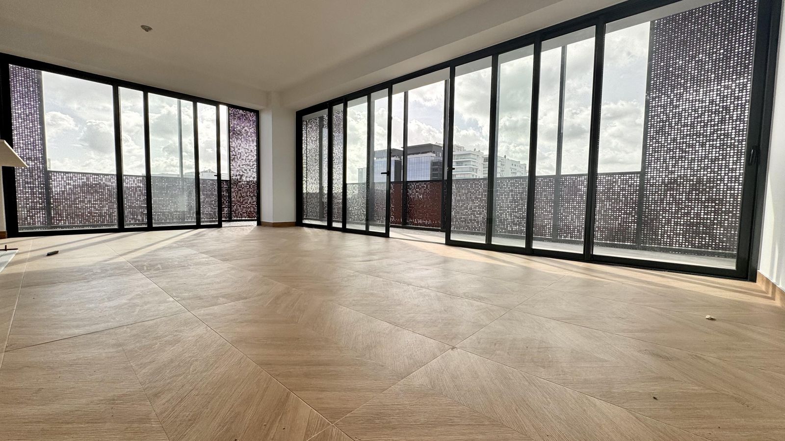 Estancia con doble altura de ventanas y celosía arquitectónica